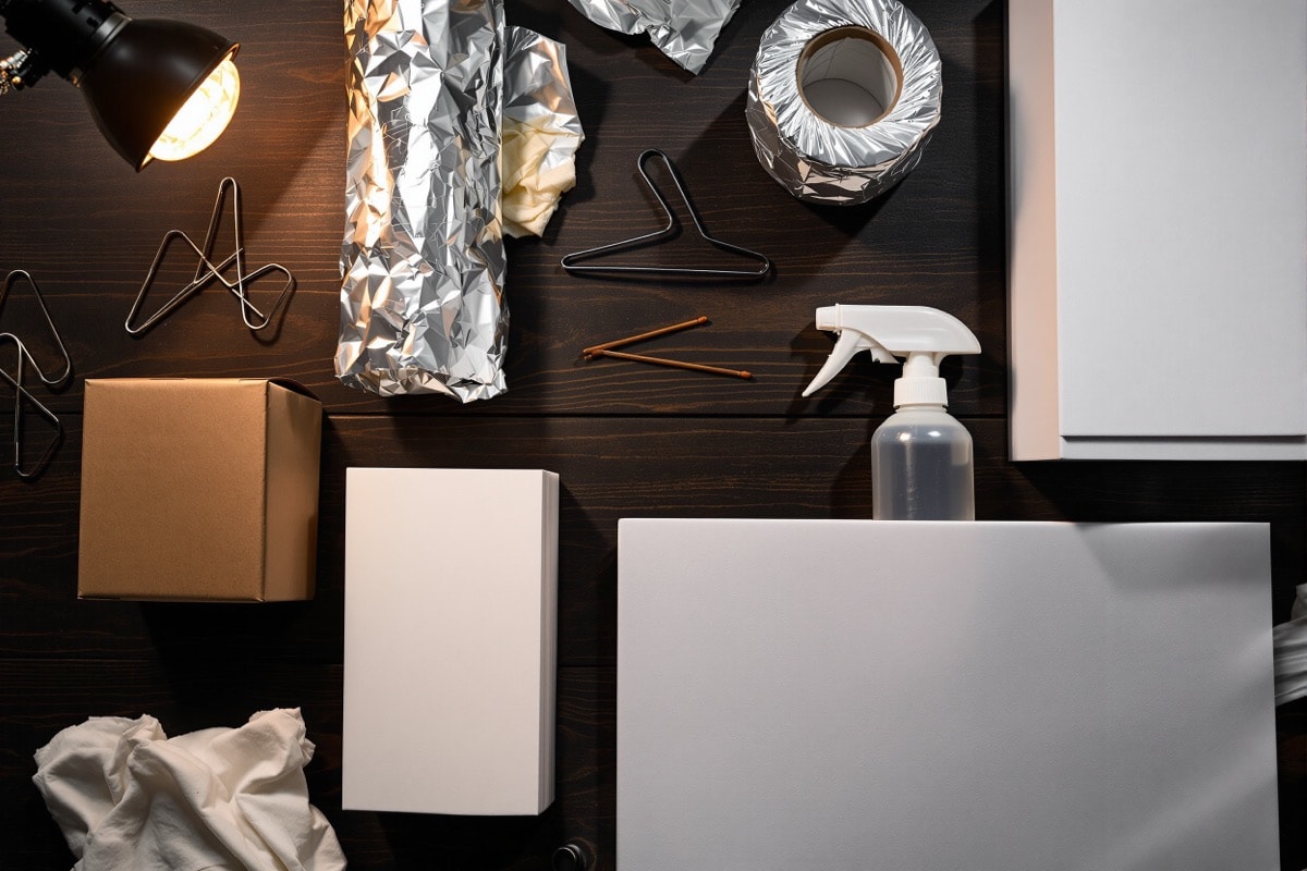 Flat-lay of coathanger wire, foil, glue sticks, tissue, wood glue and foam board